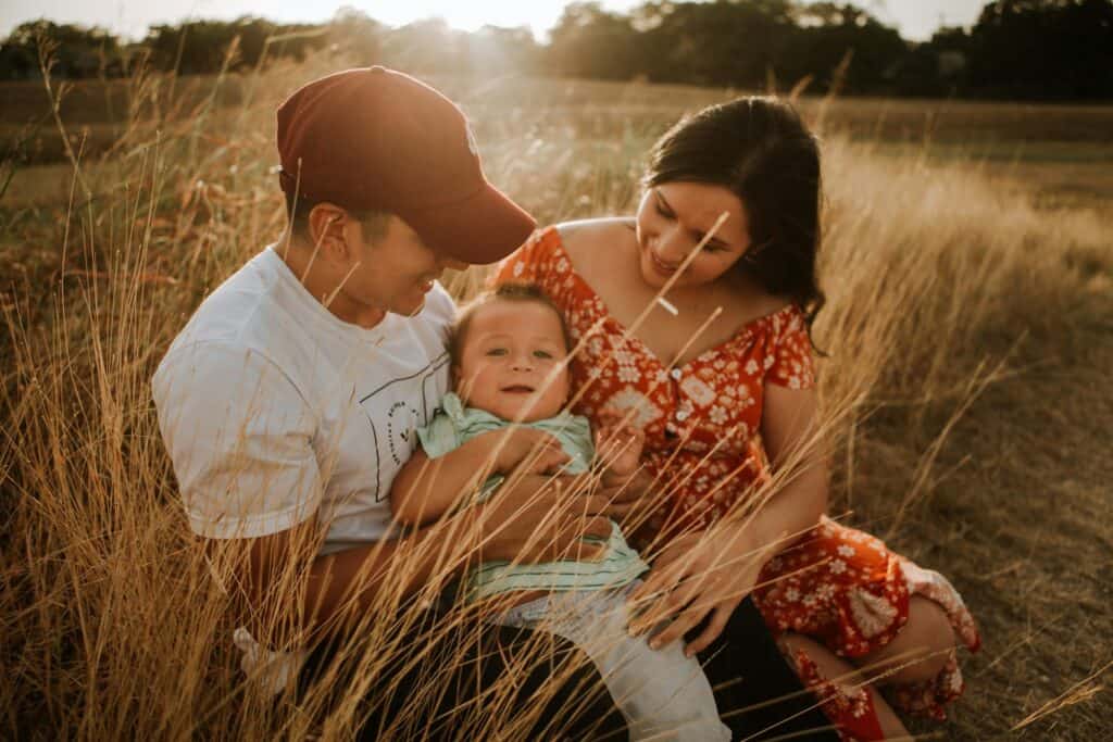 Happy family sitting together in a field, symbolizing love, security, and family-focused estate planning