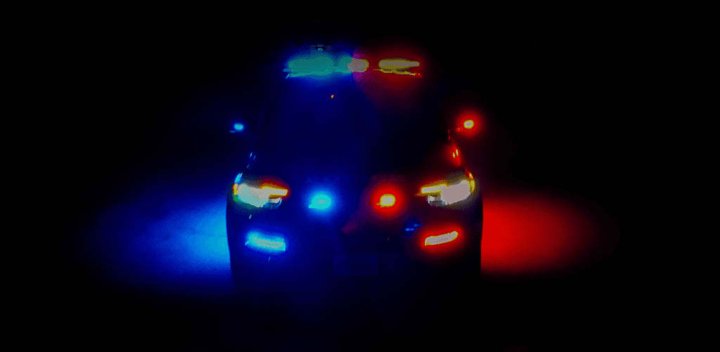 Police car at night with flashing lights, symbolizing legal support in criminal defense cases in Texas