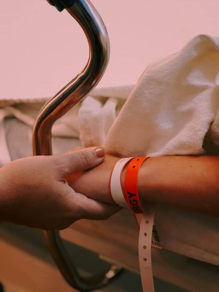 A person wearing an orange and white silicone band, symbolizing support and readiness in medical power of attorney matters